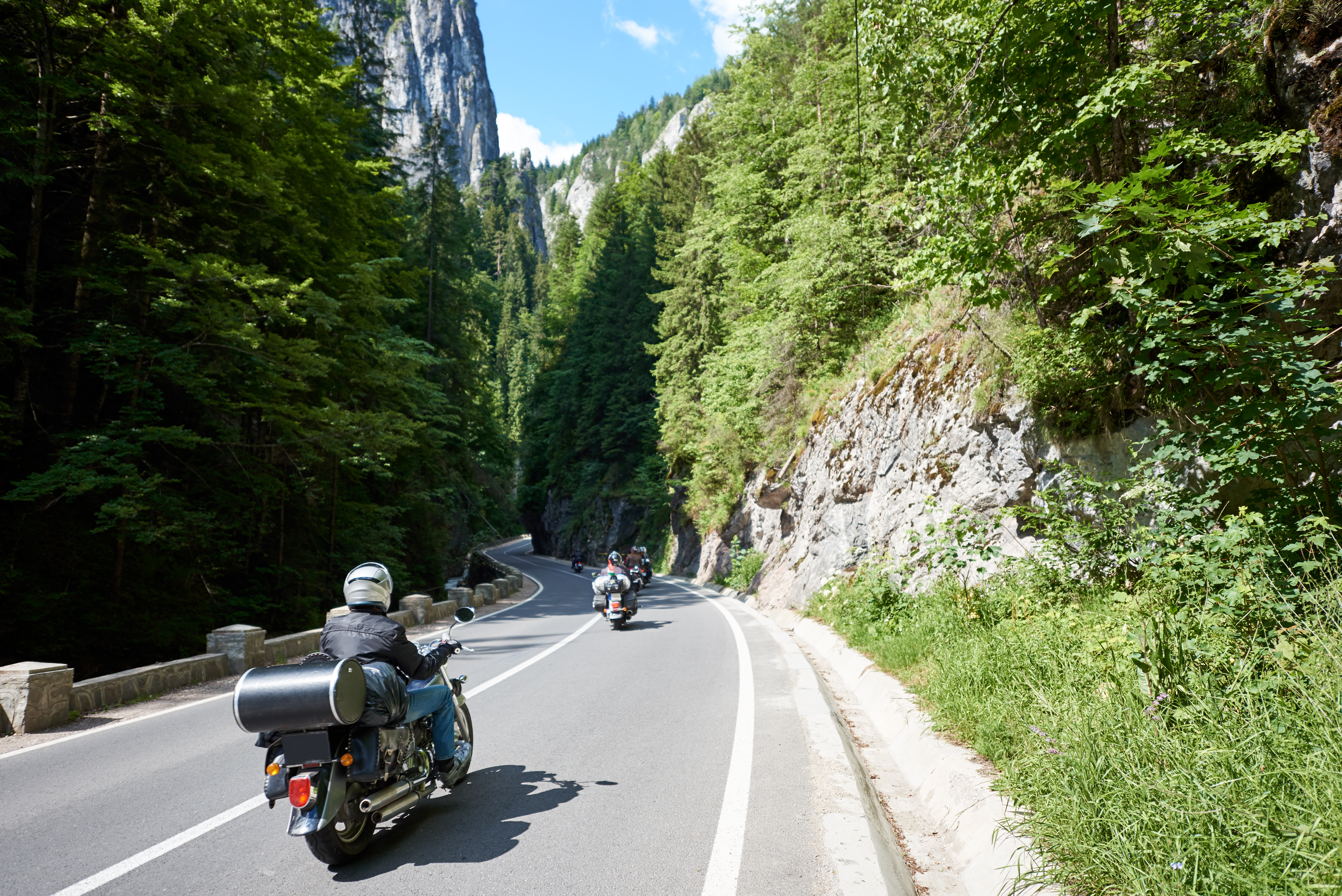 Bikers traveling on motorcycles on mountain road.